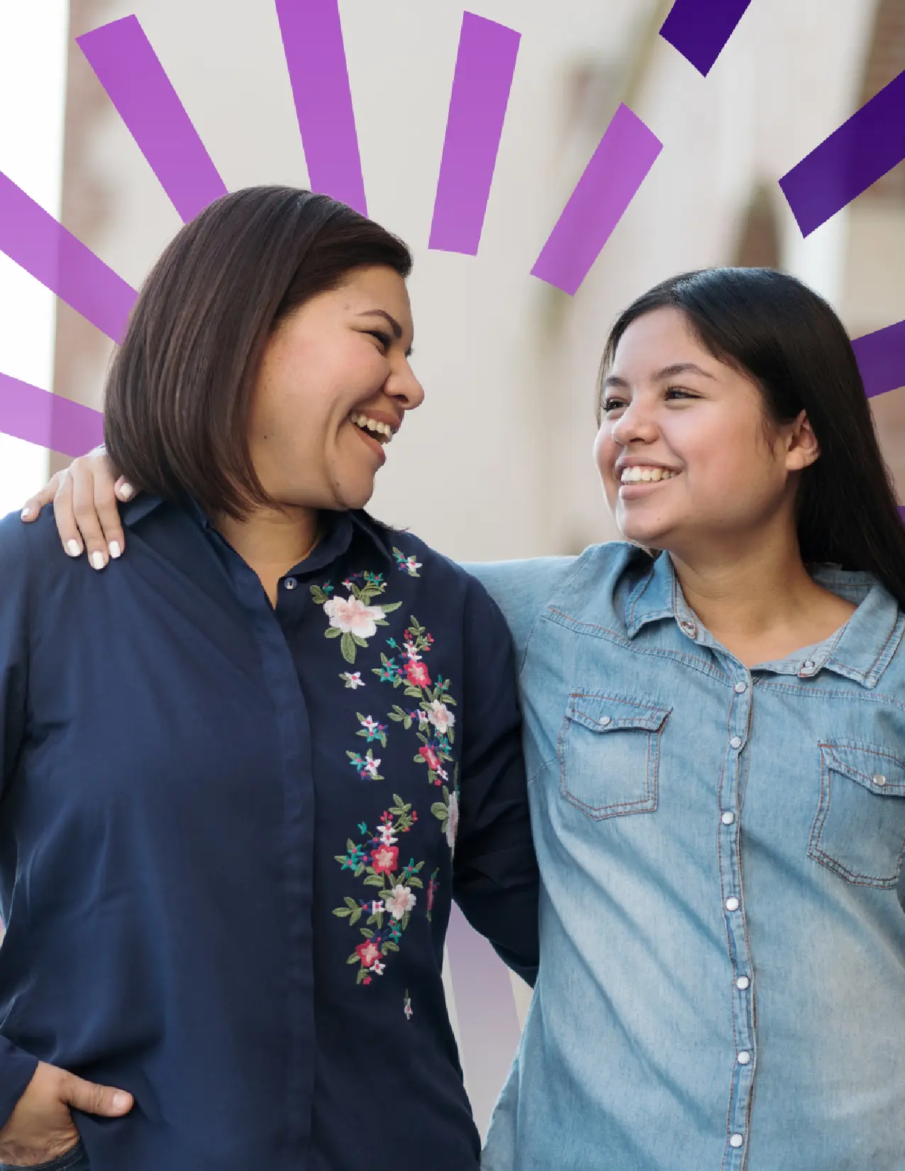 Two Hispanic women hugging and laughing