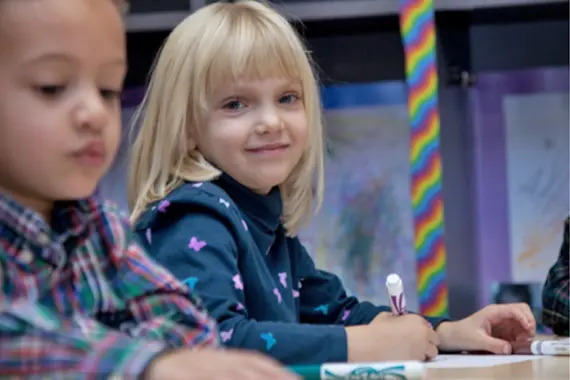 Blond toddler girl coloring with markers