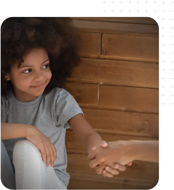 A young African-American girl holding a woman's hand