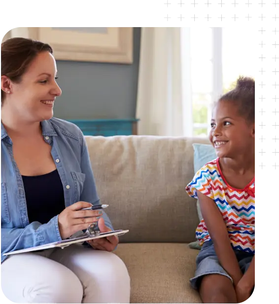 A young woman interviewing a young African-American girl