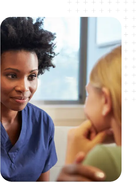 An African-American woman talking to a young caucasian woman