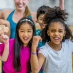 Group of excited young kids raising their fists