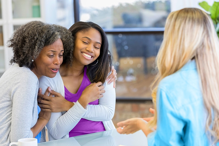 African-American mom and daughter hugging and smiling